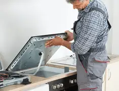 Appliance repair technician installing a built-in cooktop in Baton Rouge, LA