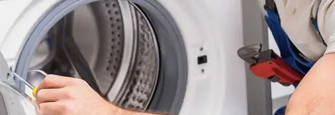 Appliance technician repairing a clothes dryer drum and internal parts in Baton Rouge, LA