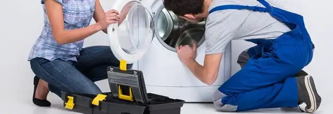 Washer repair technician inspecting a front-load washing machine with tools in Baton Rouge, LA