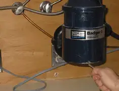 Garbage disposal repair technician tightening the mounting ring under a sink in Baton Rouge, LA