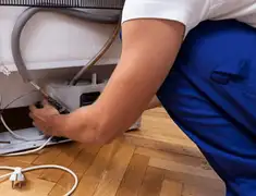 Appliance repair technician fixing refrigerator water line and connections in Baton Rouge, LA