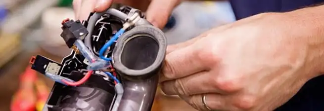 Vacuum repair technician reconnecting wiring and components in Baton Rouge, LA