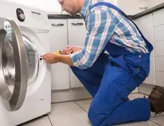 Washing machine repair technician servicing a front-load washer in Baton Rouge, LA